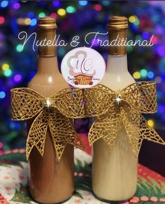 two wine bottles are decorated with gold ribbon and bowknots for the top