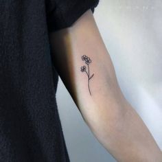 a small flower tattoo on the arm