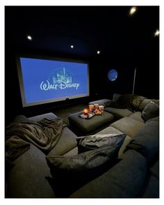 a movie theater with two couches and a projector screen in the middle of it