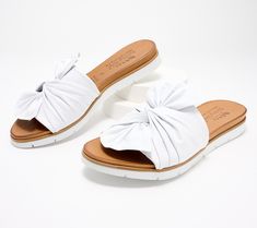 These leather sandals provide the convenience of a slip-on style wrapped up with a beautiful twisted bow. A small hidden gore adds additional adjustability, making this your go-to slide of the season. From Spring Step. Spring Slip-resistant Synthetic Slides, Spring Synthetic Non-slip Slides, Spring Synthetic Slip-on Footbed Sandals, Spring Buckle Closure Slip-on T-strap Sandals, Leather Slide Sandals, Leather Slides, Slide Sandals, Leather Sandals, Leather Upper