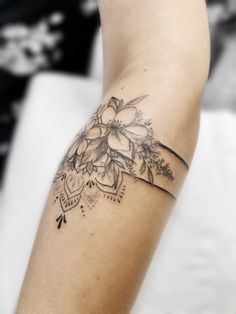 a woman's arm with a flower tattoo on the left side of her arm