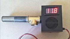 an electronic device with thermometer on top of it and wires connected to it