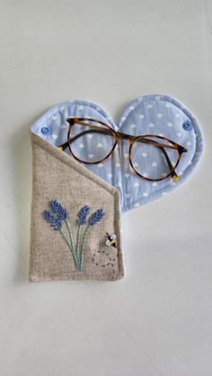 a pair of glasses sitting on top of a piece of cloth next to a blue eyeglass case