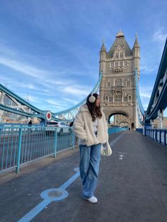 a woman is walking across the bridge