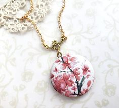 This beautiful cherry blossom locket is reminds the wearer of spring time and new life.   A beautiful gift for someone special or a treat for yourself. Locket features a watercolor image that has been permanently printed on the front of the locket and is made to be scratch resistant. Locket measures: 1 1/4 inch in diameter unopened.  The two inside areas for photos measure 1 inch in diameter.Every piece is handcrafted in my home jewelry studio and is one of a kind. Your locket will come in a gif Butterfly Locket Necklace, Summer Pendant, Gift Box For Men, Pink Cherry Blossom, Pink Cherry, Watercolor Images, Jewelry Studio, Layering Necklace, Blue Butterfly