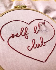 a close up of a embroidery on a piece of cloth with the words self love