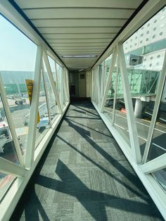 an empty hallway with large windows overlooking the street and cityscape in the background