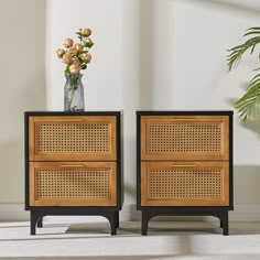 two wooden side tables with flowers in a vase on top and one is made out of rattan