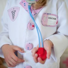 "The doctor is in! Look the part in this complete ensemble as you diagnose and treat pretend patients with this 8 piece dress-up-and-play set. The set includes a white doctor's coat, green or pink scrub pants, a green or pink fabric mask, white hat, play stethoscope, play syringe, and play thermometer. The coat also features a sewn in doctor's name tag holder with removable name tag and Velcro on and off. All our Great Pretenders Career Costumes are packaged in a reusable blue garment bag for ea Knight Costume For Kids, Career Costumes, Doctor Coat, Doctor Dress, Doctor Costume, Pink Scrubs, Mask White, Fabric Mask, Dress Up Outfits