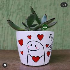 a potted plant with hearts painted on it and the words love is in spanish