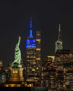 the statue of liberty is lit up in blue and white