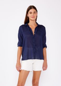 [Color: Navy] A brunette woman wearing a sheer blue shirt with a collared neckline Classic Shirt With Roll-up Sleeves For Day Out, Summer Tops With Roll-up 3/4 Sleeves, Summer Half-sleeve Blouse With Roll-up Sleeves, Summer Half Sleeve Blouse With Roll-up Sleeves, Relaxed Fit Blouse With Button Closure For Casual Wear, Summer Blouse With Roll-up Sleeves And Shirttail Hem, Summer Tops With Roll-up Sleeves For Casual Gatherings, Summer Shirt For Day Out With 3/4 Sleeves, Daywear Button-up Blouse With Roll-up Sleeves