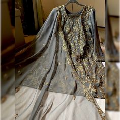 New... Never Worn Before. Gray Color Dress With Golden Work On The Shirt Piece And Duppata. Along With Banarsi Trouser. The Shirt Has Inner Lining Attach With The Kameez. Graceful Attire For Party Or Wedding Wear. Pakistani, Indian, Bangladeshi, South Asian Semi-Casual Party Wear. Measurements Shalwar (Trouser) 38 In Bust 21 Inch Waist 20 In Hips 23 In Shirt Length 37.5 In Sleeves Length 21 In Festive Unstitched Gray Kurta, Elegant Gray Sets With Zari Work, Gray Fitted Party Sets, Elegant Gray Kurta For Eid, Gray Kurta For Wedding And Eid, Elegant Gray Designer Wear Sets, Gray Festive Sets With Resham Embroidery, Gray Traditional Festive Sets, Festive Gray Long Sleeve Sets