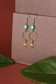 Lovely earrings with natural turquoise stone 6 mm beads, gold tone hoops, seafish charms and gold tone earring hooks. Earring hooks are from nickel free and lead free metal. Perfect for everyday wear! *The total lenght of earrings is about 59 mm including the earring hooks. Other earrings of my shop you can see here: https://www.etsy.com/shop/NaTavelli?section_id=13757927 Thanks for visit. Gold Metal Hoop Earrings For Beach, Gold Pierced Hoop Earrings For Beach, Gold Dangle Earrings For Beach, Gold Earrings For Beach, Shells Earrings, Turquoise Stone Earrings, Blue Gemstone Earrings, Natural Turquoise Stone, Cowrie Shells