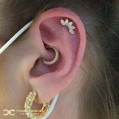 a woman wearing gold ear piercings with diamond leaves on the side of her ear