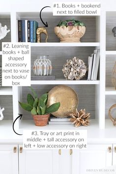 a white bookcase filled with lots of books next to a potted plant and other items