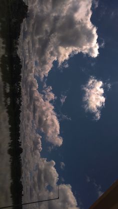 some clouds are in the sky and one is on top of a building with a clock tower