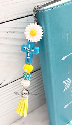 a book with a cross and a flower on it next to a keychain