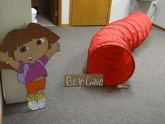 there is a sign that says dear cave next to a cartoon character on the floor