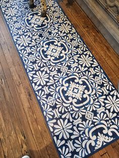 a large blue and white rug sitting on top of a wooden floor next to a fireplace