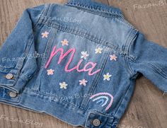 One design is 8 floral, 6 hearts, daisies, and retro flowers, 4 stars, Rainbows, clouds, smiling faces, roses, half of the sun, and the sun are one. Colorful names are also a design 🎨 Artisan-Crafted Introducing our essential Baby & Toddler Denim Jacket, meticulously handmade with love and featuring a trendy denim aesthetic. This personalized jacket becomes a cherished and distinctive gift, perfect for birthdays, baby showers, or any special milestone. 🌟 Highlighted Features: Handmade, Customi Colorful Names, Denim Jacket Embroidery, Denim Aesthetic, Name Unique, Jacket For Girls, Personalized Jacket, Kids Jackets, Smiling Faces, Unique Birthday Gift