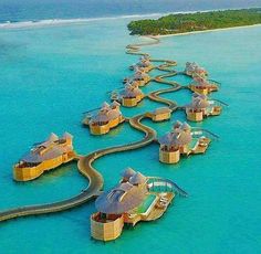 an aerial view of the resort in the middle of the ocean with water running through it