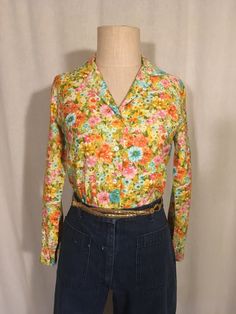 "1960s women's button up blouse label- christenfeld capers cotton feel multi-color floral print long sleeve open collar breast darts straight hem good vintage condition, light wear smaller than labeled size 10, see below measures, lying flat, shoulder-14 1/2\" chest-17\" sleeve-21 1/2\" length-26 1/2\" 4\" side slits" Retro Spring Button-up Shirt, Fitted Collared Shirt With Floral Print, Fitted Spring Shirt With Buttons, Fitted Shirt With Buttons For Spring, Vintage Print Collared Tops For Spring, Vintage Retro Print Tops For Spring, Spring Collared Tops With Vintage Print, Spring Vintage Print Collared Tops, Spring Vintage Tops With Retro Print