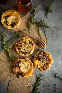 three small pies sitting on top of a wooden cutting board next to a honey comb