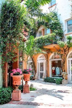 the entrance to an apartment building with potted plants