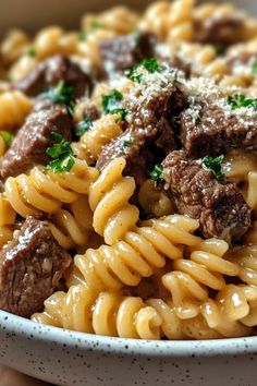 a white bowl filled with pasta and meat