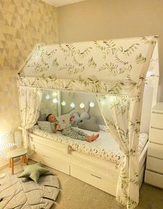 a child's bed with a canopy over it and lights on the sides, in a bedroom