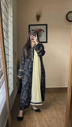 a woman taking a selfie in front of a mirror wearing a blue and white dress