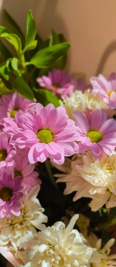 a bunch of pink and white flowers in a vase