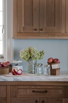 the kitchen counter is covered with apples and flowers