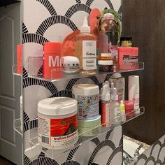 a bathroom shelf filled with lots of different types of cosmetics and personal care products on it