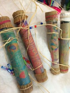 four different colored tubes are wrapped in twine