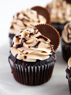 chocolate cupcakes with frosting and heart shaped decorations on white plate, closeup