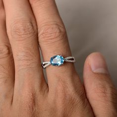 This is a gorgeous handmade creation. Its beauty is its simplicity & Elegance. The 6*8 mm oval shape faceted real Swiss Blue Topaz is crafted in solid sterling silver and with rhodium plated. Main stone weight about 1.47 ct. CZ as accents. All item is sent in a beautiful gift box If you have any idea of design your ring,pls contact me directly. You can realize more lovely stuff clicking the link https://www.etsy.com/shop/knightjewelry?refshopsection_shophome_leftnav Please leave the correct Oval Faceted Birthstone Ring For Anniversary, Oval Blue Topaz Ring With Accent Stones, Oval Faceted White Gold Rings, Faceted Oval Topaz Ring Gift, Oval Blue Topaz Ring In Fine Jewelry Style, Oval Blue Topaz Ring Fine Jewelry, Oval Topaz Birthstone Ring With Gemstone, Fine Jewelry Oval Blue Topaz Ring, Oval Topaz Birthstone Ring