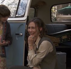 two women sitting in the back of a van