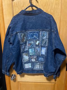 an old jean jacket is hanging on a wooden closet door and it has been altered to look like something out of space