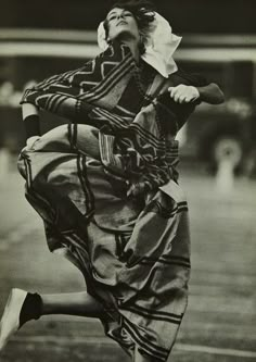 an old photo of a woman jumping in the air