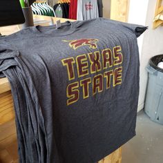 Fight the Texas heat and look great doing it in a Nudge Printing premium t-shirt! Every shirt is printed by hand with nothing but the finest inks and screens on a premium cotton-polyester blend for extreme comfort whether you're walking through campus or traveling the world. Go Bobcats! o Officially licensed with Texas State University o Screen-printed in Michigan, USA o Super soft 60% cotton 40% polyester blend - so soft you'll want to sleep in it! o Preshrunk for accurate unisex sizing Gray Screen Print Tops For College, Graphic Tee Shirt With Heat Transfer Vinyl For Fans, Gray Text Print Fan Apparel Top, Gray Fan Apparel Top With Text Print, Gray T-shirt With Letter Print For Fans, Gray Logo Print T-shirt For Fans, Gray Fan Apparel T-shirt With Letter Print, Gray Letter Print Fan Apparel T-shirt, Gray Logo Print T-shirt For Fan Gear