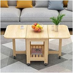 a wooden table with fruit on it in front of a couch and potted plant