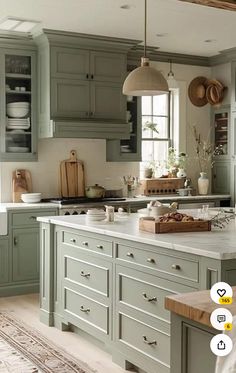 a kitchen filled with lots of green cupboards and counter top next to a window