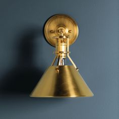 a brass light fixture on a blue wall