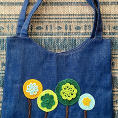 a blue bag with crocheted flowers on it