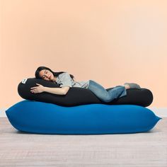 a woman laying on top of a blue pillow