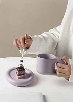 a person cutting into a piece of cake on top of a plate with a fork