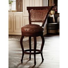 a wooden bar stool with an upholstered backrest and foot rests on a hardwood floor