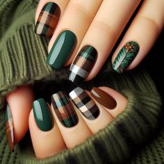 A forest-green base with plaid patterns in shades of brown, black, and white on a couple of accent nails. The plaid is hand-painted, adding a cozy, autumnal feel, reminiscent of warm flannel shirts and blankets. The combination of earthy colors and patterns captures the essence of fall fashion. Christmas Finger Nail Ideas, November Nails Plaid, Thanksgiving Nails Plaid, Patchwork Nail Art, Fall Flannel Nails, Plaid Fall Nail Designs, Autumn 2024 Nails, Fall Plaid Nail Designs, Dark Green Fall Nails